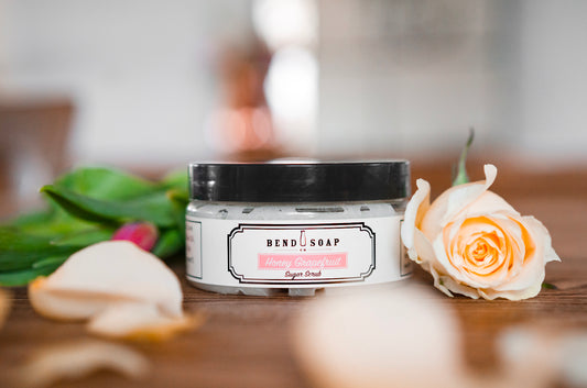 Honey Grapefruit Sugar Scrub on a Wood Table Surrounded by Roses