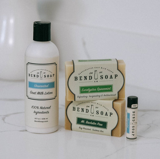 The Best for Men Bundle from Bend Soap Co. includes Goat Milk Soap bars in Eucalyptus Spearmint and Mt. Bachelor Pine, an Unscented Lotion bottle, and a lip balm tube, all shown on a white surface.