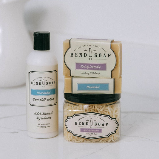 The Best for Babies Bundle includes an unscented goat milk lotion, Goat Milk Soaps in Hint of Lavender and Unscented, plus a jar of luxury Lavender Milk Bath shreds, all beautifully displayed on a white surface.