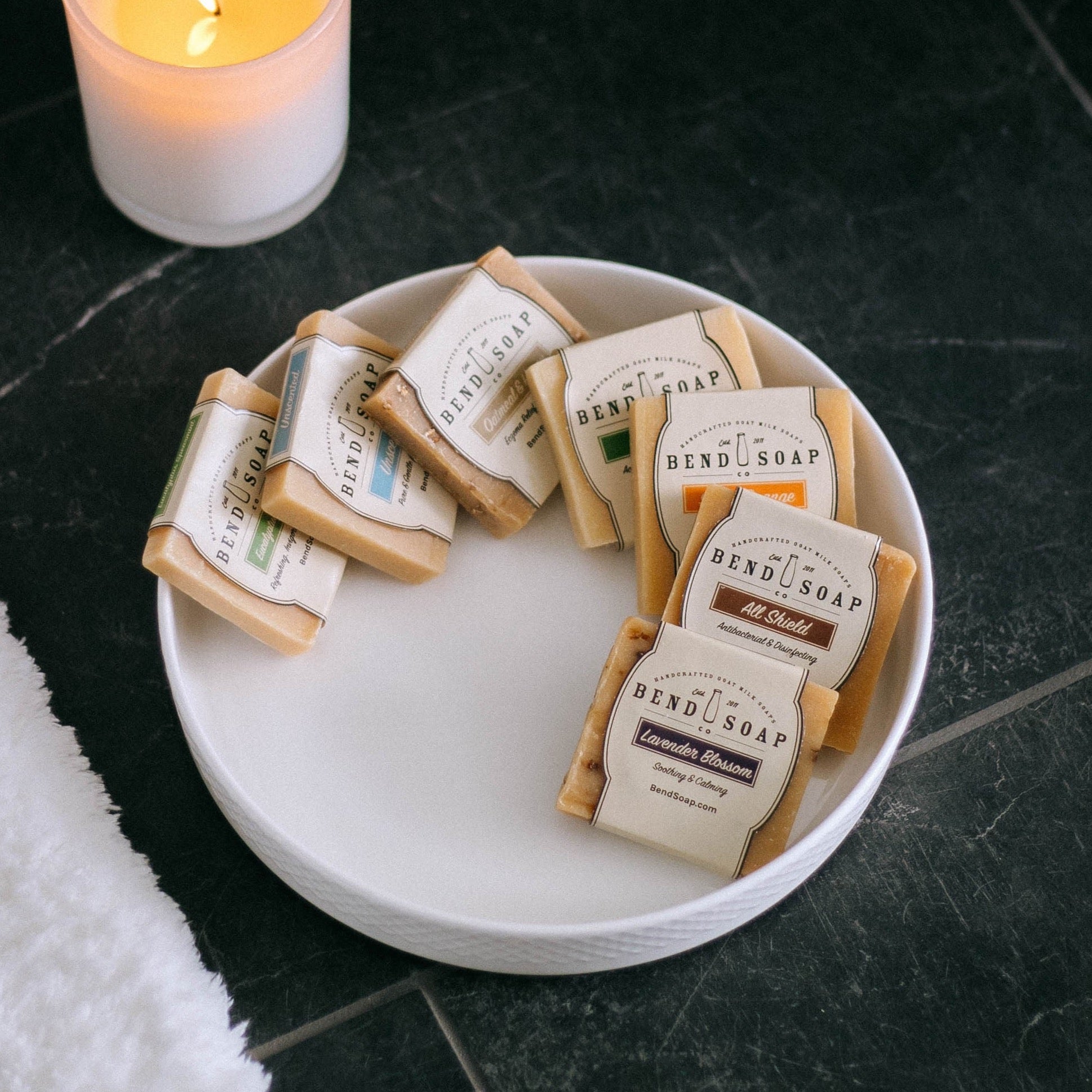 Variety of travel sized goat milk soaps in a platter