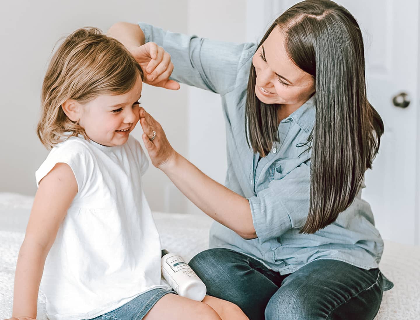 mother applies all-natural goat milk lotion to daughters face