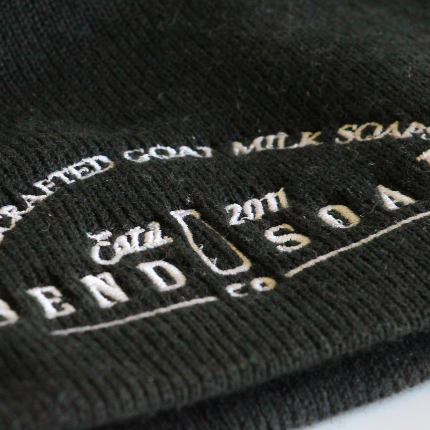 Close up of the Kid black beanie with Bend Soap Company logo