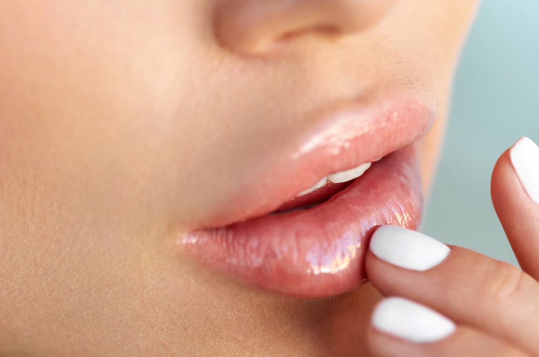 Woman touching her smooth glossy lips