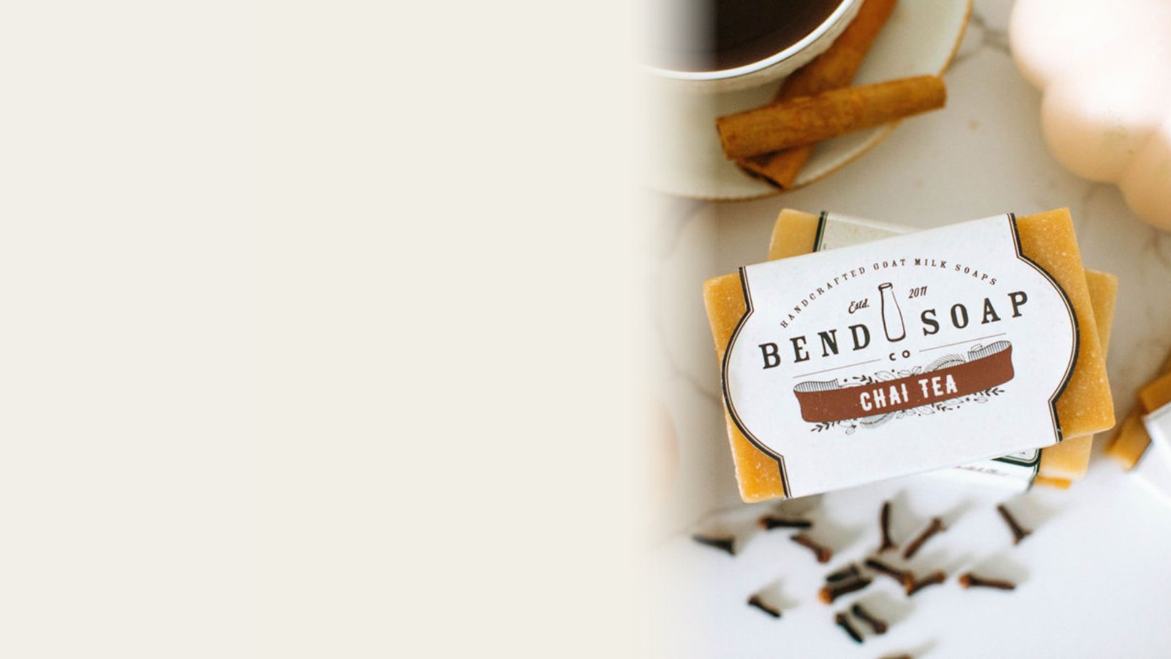 Chai tea goat milk soap surrounded by spices on a wooden table