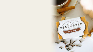 Chai tea goat milk soap surrounded by spices on a wooden table