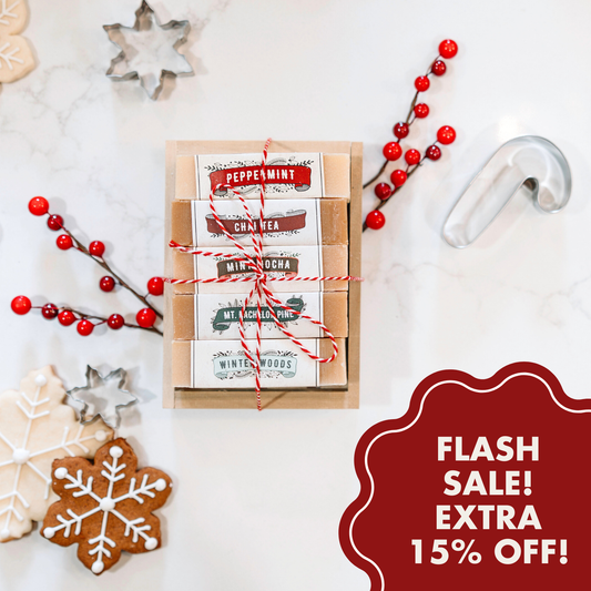 A festive gift box of The Winter Wonder Bundle all-natural soap, tied with red and white string, sits among holiday cookies and snowflake decorations. Text: "FLASH SALE! EXTRA 15% OFF!.