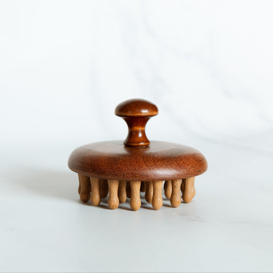 Wooden brush with a round handle on a white background