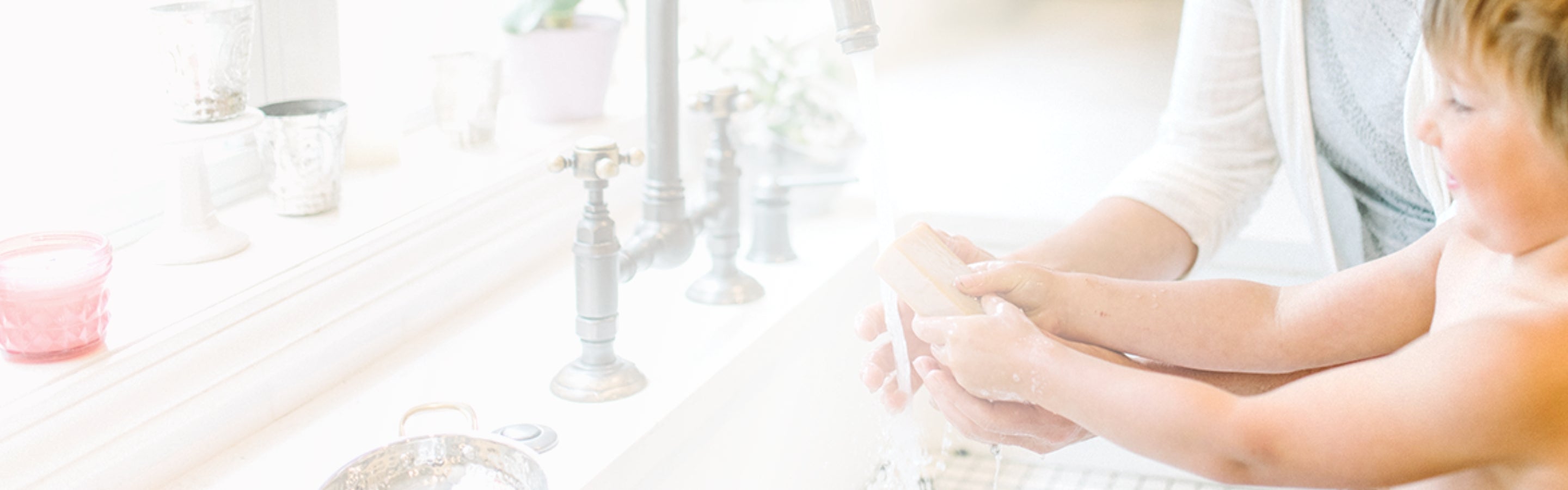 Mother washing child's hands with goat milk soap