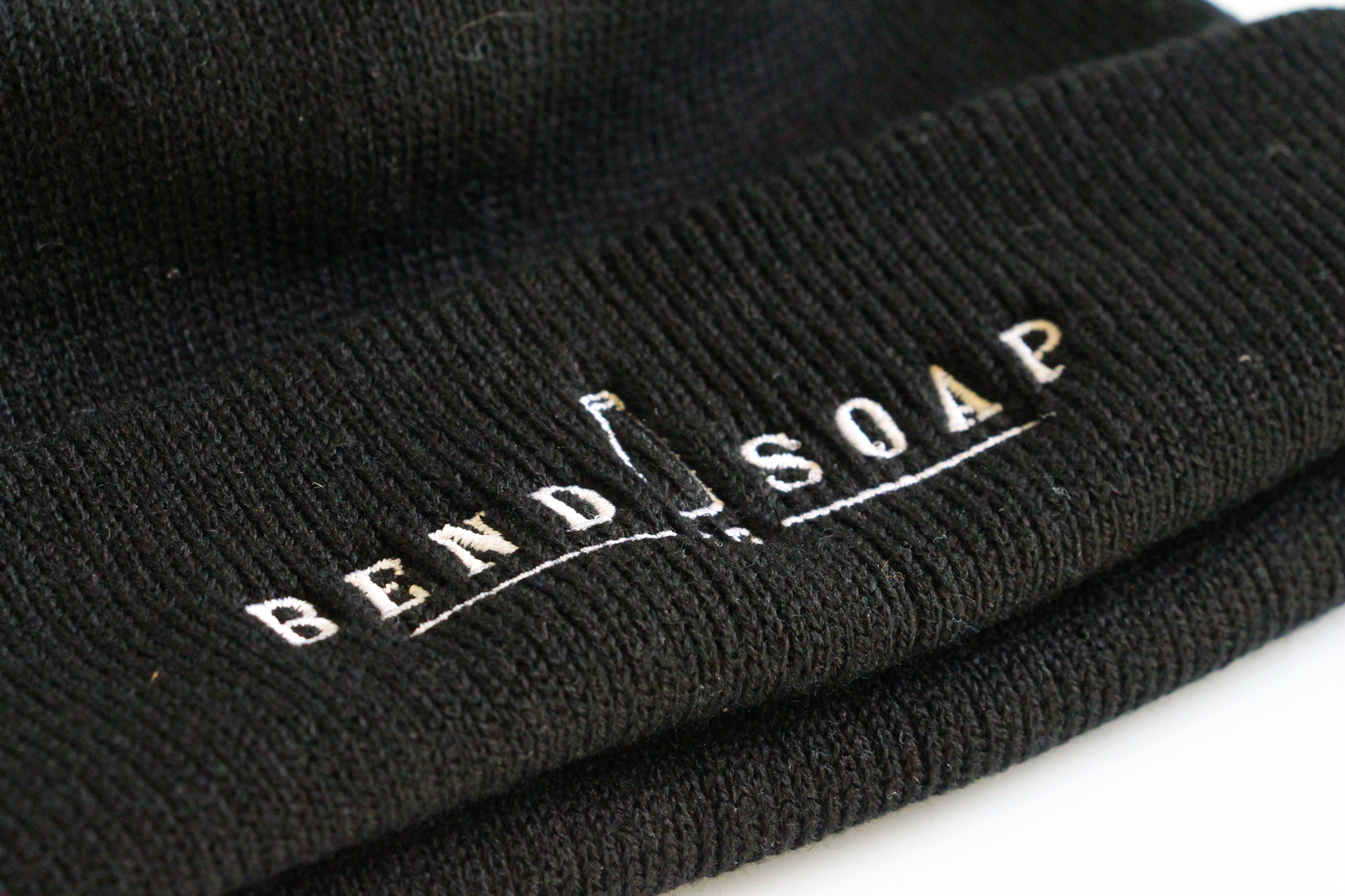Close up of the Adult black beanie with Bend Soap Company logo