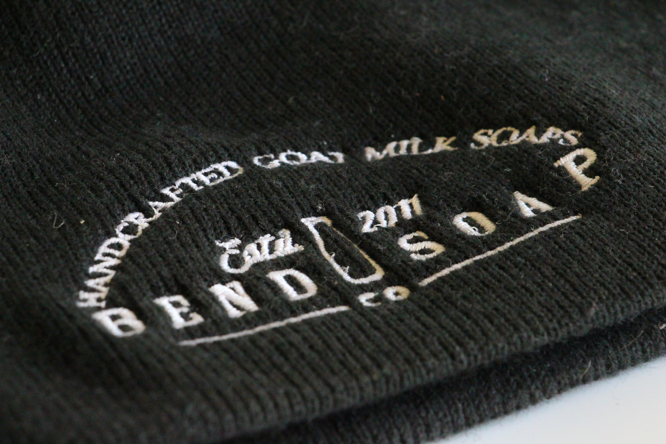 Close up of the Kid black beanie with Bend Soap Company logo