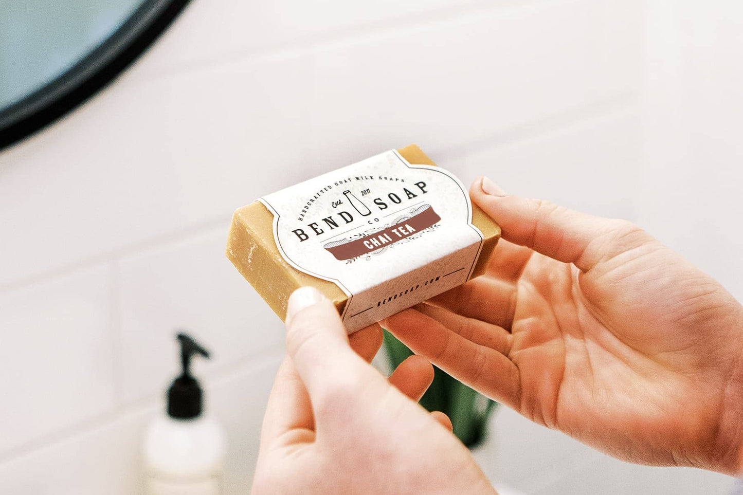 A woman's hands holding a full-size bar of chai tea goat milk soap